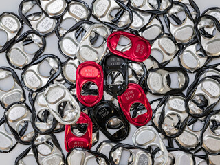 Can tabs with codes on the backside for sweepstakes and raffles. A heap of objects from soft drink cans. Pull tabs to open the canned beverages.