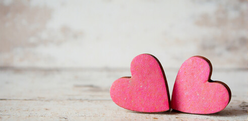 Obraz premium Valentines day background with two red hearts on wooden background