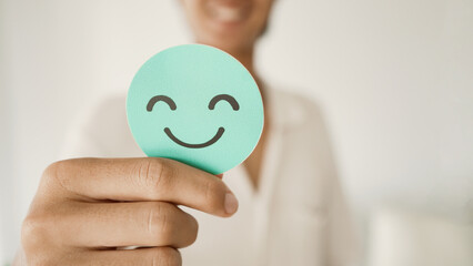 Male Teen holding smile emoji face, positive mental health, world mental health day concept