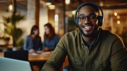 Fototapeta premium Smiling male support agent with headphones, sitting at a desk