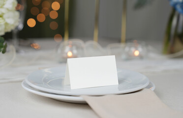 Mockup white blank space card, for Name place, Folded, greeting, invitation on wedding table setting background. with clipping path
