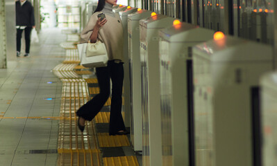 朝の名古屋駅のホームで電車に乗る人々の姿