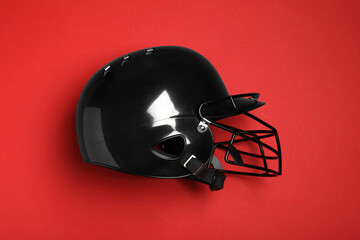 Black baseball helmet on red background, top view