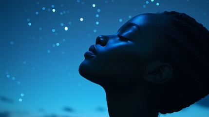 Side view, a african american woman looking up to a blue starry sky at night