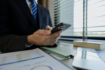 Businessman dressed in a suit is working in an office at a company. A senior executive is in a private office and doing many things. The atmosphere of a private office is calm and peaceful.