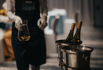 Close up of waiter in a fancy restaurant holding jug of wine