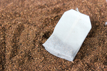 Tea bag with tea powder background.