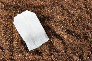 Tea bag with tea powder background.