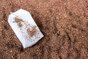Tea bag with tea powder background.