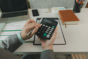 Typical office work atmosphere for company employees. A businessman is diligently handling important documents in his personal office. Important project report documents are being analyzed by experts.