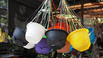 Various flower pots in various colors, made of plastic, displayed by hanging them from the ceiling