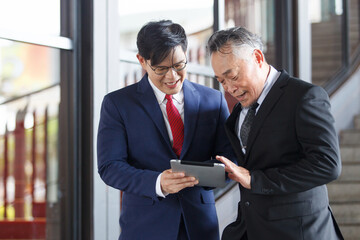 Two Asian businesspeople having a business discussion in the office building.