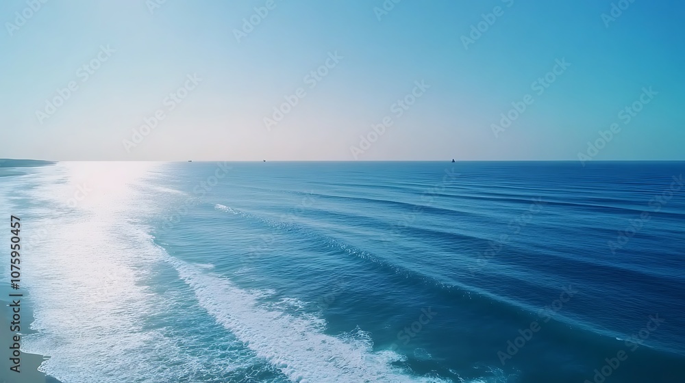 Poster A serene view of the ocean with gentle waves reflecting sunlight, creating a tranquil atmosphere under a clear blue sky.
