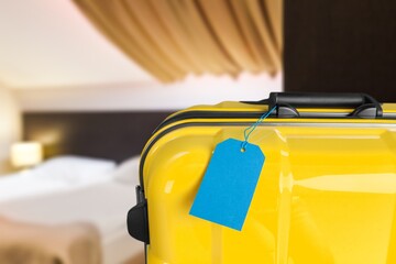 Modern travel Suitcase near bed in hotel room