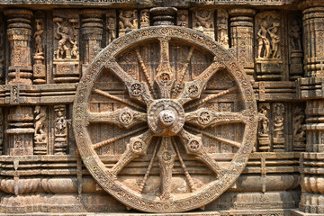 A stone wheel engraved in the walls of Konark Sun Temple (Odisha, India) isolated white background.