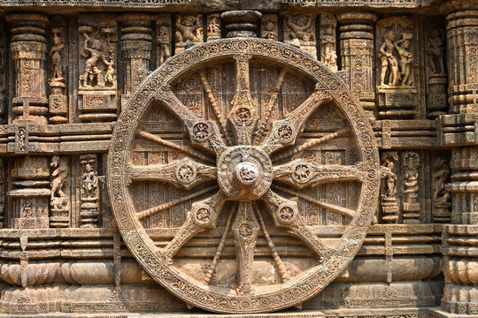 A stone wheel engraved in the walls of Konark Sun Temple (Odisha, India) isolated white background.