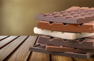 Broken dark sweet chocolate bar on desk