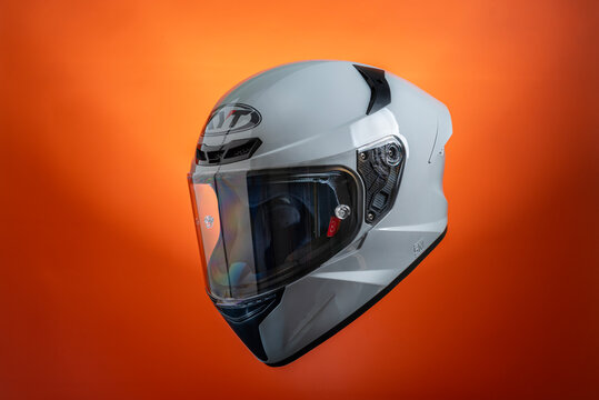 Full face grey KYT motorcycle helmet on red orange background