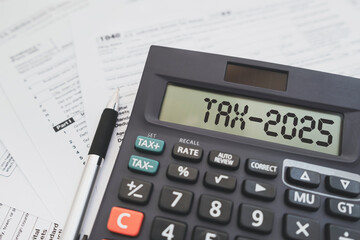 Text Tax 2025 on the calculator and taxes documents. Business and Annual tax concept.