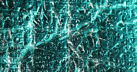 Color droplet. Flowing water. Dispersion on bubble film turquoise glossy surface. Condensation chaotic shimmering wetness cascade on deformed foil.