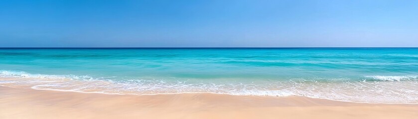 Obraz premium Breathtaking beach scene featuring clear blue water, gentle waves, and pristine sandy shoreline under a bright blue sky. Perfect for relaxation imagery.