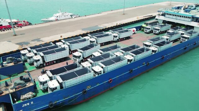 The truck was loading onto a into carrier ship. Car ferry leaving docks fully loaded.