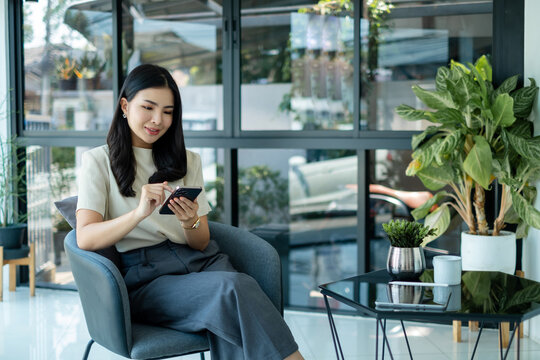 Female CEO in casual wear smiling and using smartphone working Shown on the digital screen analyze and calculate the planning strategy for modern business