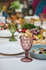 A table full of food and drinks with a variety of dishes and glasses. Scene is inviting and celebratory