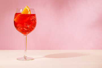 A cocktail arranged on a table against a light pink background