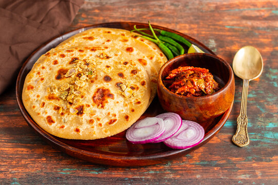 Sattu paratha is a flavorful flatbread from Uttar Pradesh and Bihar, filled with roasted gram flour, served with pickle and raita.
