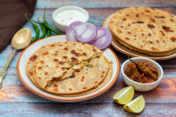 Sattu paratha is a flavorful flatbread from Uttar Pradesh and Bihar, filled with roasted gram flour, served with pickle and raita.
