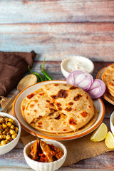 Sattu paratha, a stuffed flatbread from Uttar Pradesh and Bihar, is filled with spiced roasted gram flour and served with pickle and raita.