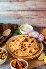 Sattu paratha is a flavorful flatbread from Uttar Pradesh and Bihar, filled with roasted gram flour, served with pickle and raita.