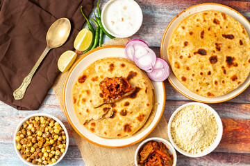 Sattu paratha is a flavorful flatbread from Uttar Pradesh and Bihar, filled with roasted gram flour, served with pickle and raita.