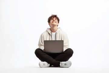 Happy young male student winner sitting isolated on white background using laptop computer celebrating admission, good test results, online win or achievement.