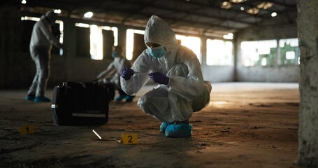 Crime, people and forensics at scene with sample, evidence and DNA swab with clue in abandoned warehouse. CSI team, hazmat suit or investigation in building for legal service, inspection or pathology