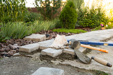 Laying paving stones on cement mortar. Laying a garden path made of tiles. Self-laying of concrete paving slabs in the courtyard of the house. do it yourself. DIY