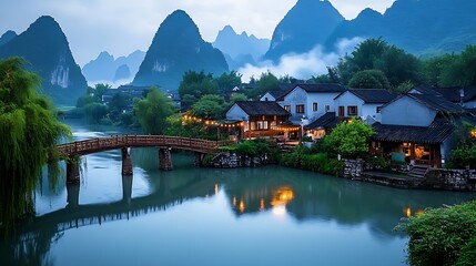 Fototapeta premium A picturesque village nestled amidst mist-covered mountains, with a wooden bridge spanning a tranquil river.