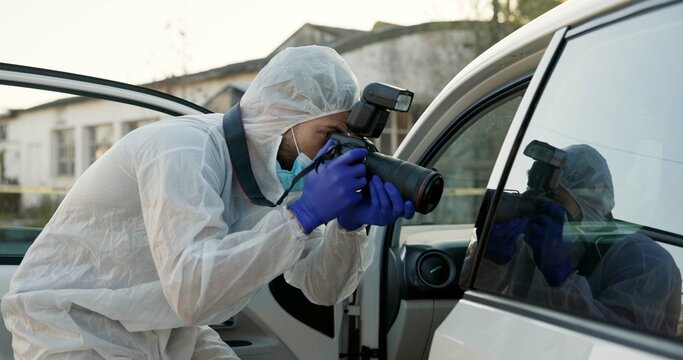 Man, forensic photographer and camera at crime scene by car for evidence, inspection and police in street. Person, investigation and photography for problem solving, statistics and ppe on metro road