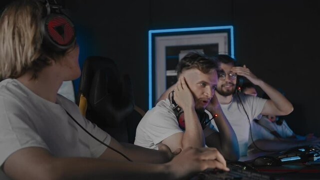 Match defeat, player choked round in shooter. Gamers lost map due to fault of 1 guy, teammate threw game, he clutched at his head. Noob looser. 5 men play multiplayer online strategy in computer club
