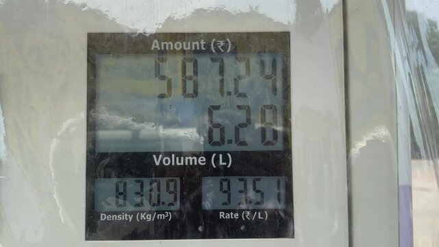 closeup of petrol pump display unit showing prices in rupee with moving numbers