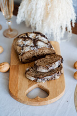 A freshly baked loaf of warm bread is beautifully sitting on a charming rustic wooden cutting board, eagerly waiting to be sliced and served for a delightful meal or enjoyable snack