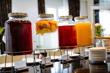 A visually appealing display of refreshing beverages featuring a variety of infused drinks elegantly arranged at a modern buffet setup