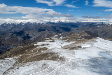 Pambak Range cowered with snow on sunny spring day. Aerial view from above Mariam summit....