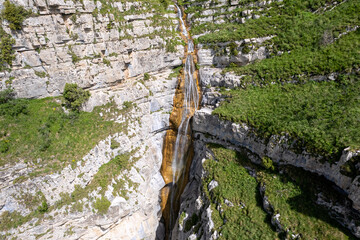 Aerial view of waterfall near by Mount Dimats on sunny spring day. Haghartsin, Armenia.