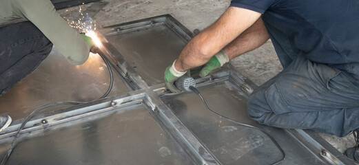 A welder fixing a new metal gate.