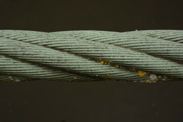 Steel cable on a water surface close-up coated with green rust paint with some lichen spots