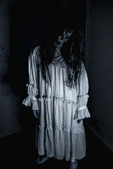 portrait female ghost with a face full of hatred and horror wearing a white dress in a haunted room
