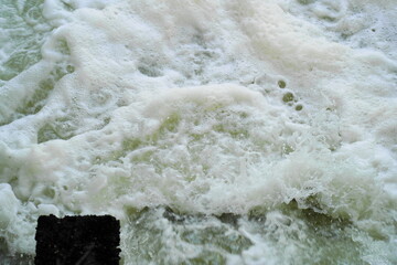 Turbulent water gushing spurts at the base of a dam