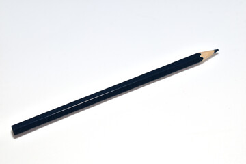 A simple black pencil lies on a white background.